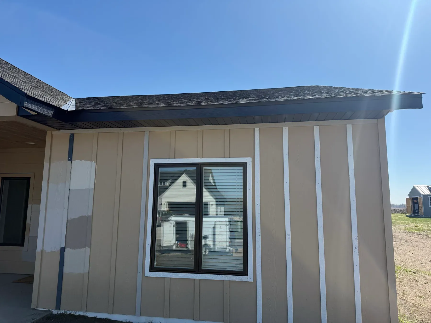 Front eave with new seamless gutter on a beige home