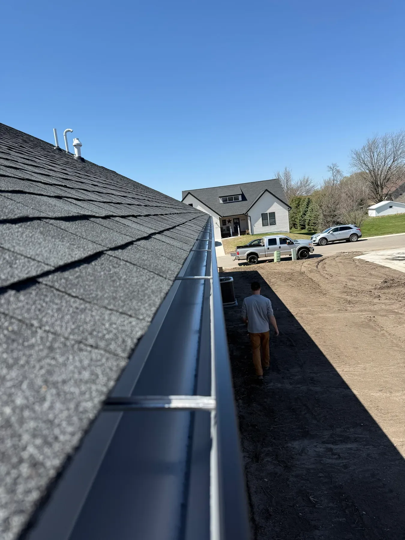 Long seamless gutter run along a shingle roofline